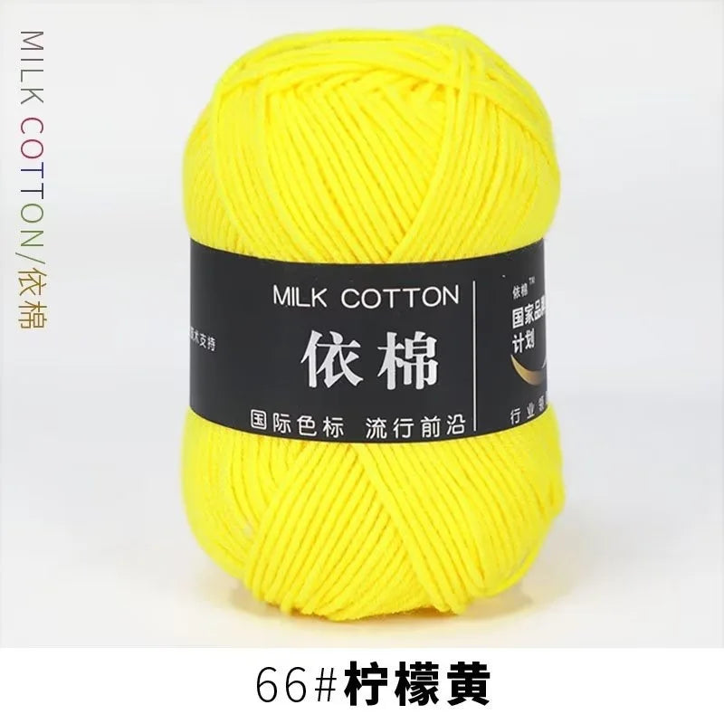 A ball of bright yellow milk cotton yarn labeled with the brand name and fiber content.