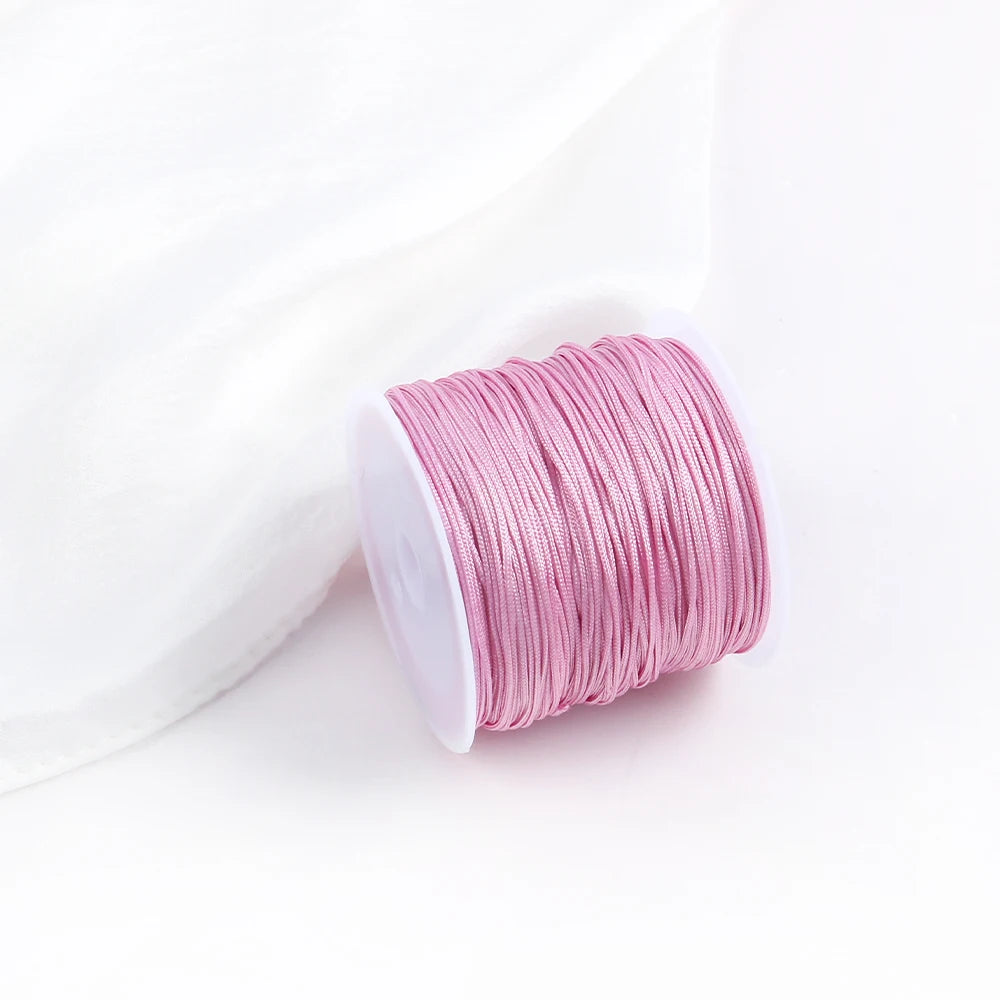 A roll of pink cotton nylon macrame cord for jewelry making and crafts is shown against a white background.