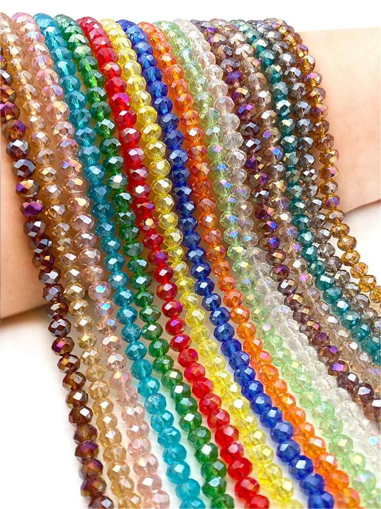 A close-up of multiple strands of colorful, faceted crystal beads in various shades of pink, blue, green, yellow, orange, and