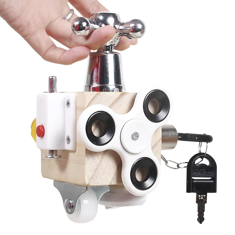 A wooden busy cube sensory learning toy with a metal faucet and a small black key attached.