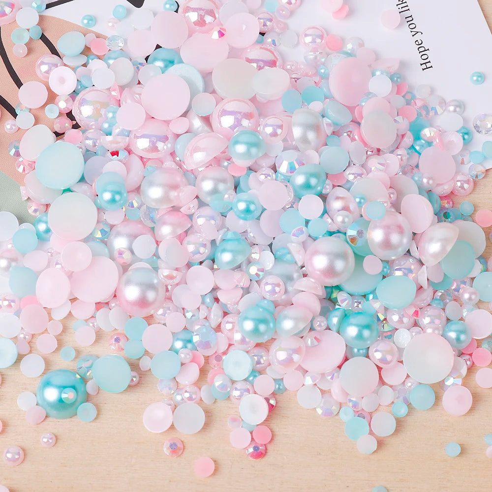 A pile of mixed resin rhinestone pearls in pink and blue shades with an AB finish for crafts and nail art.