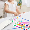 A child is painting with a portable watercolor book featuring various colored paint palettes and brushes.