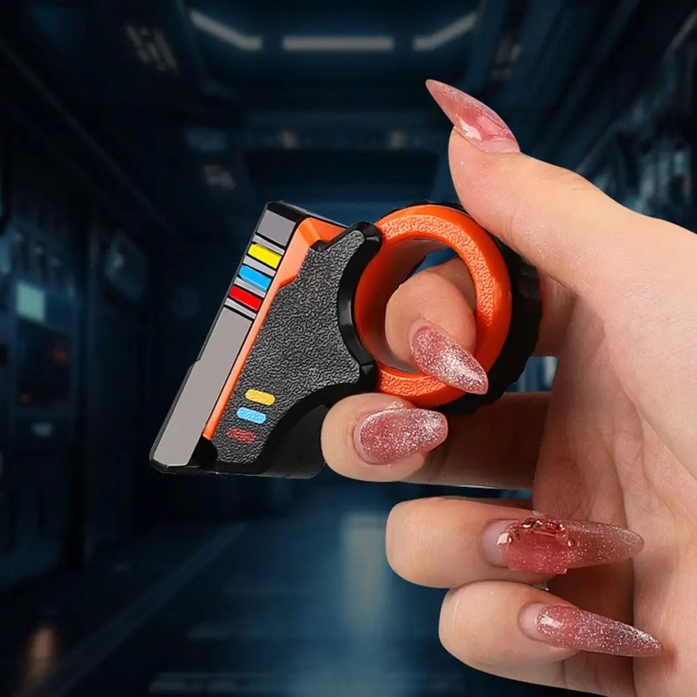 A hand holds an orange and black rotary finger slider fidget toy against a dark, futuristic background.