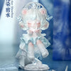 A white collectible figurine of a girl with cat ears and a crown, holding a small object, set against a blue background.