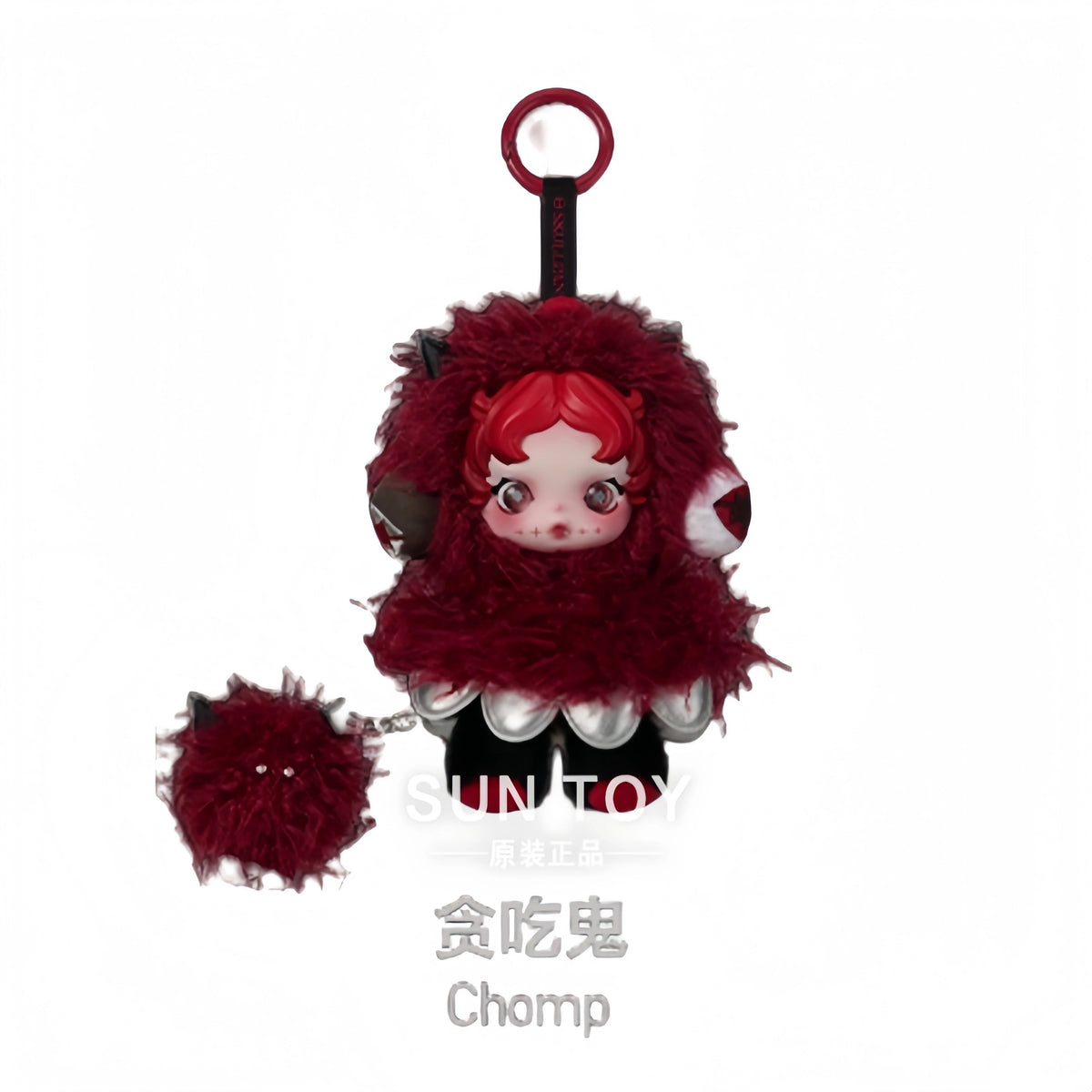 A collectible figure of a small, red-haired creature with fluffy red fur and black accents, suspended by a loop.