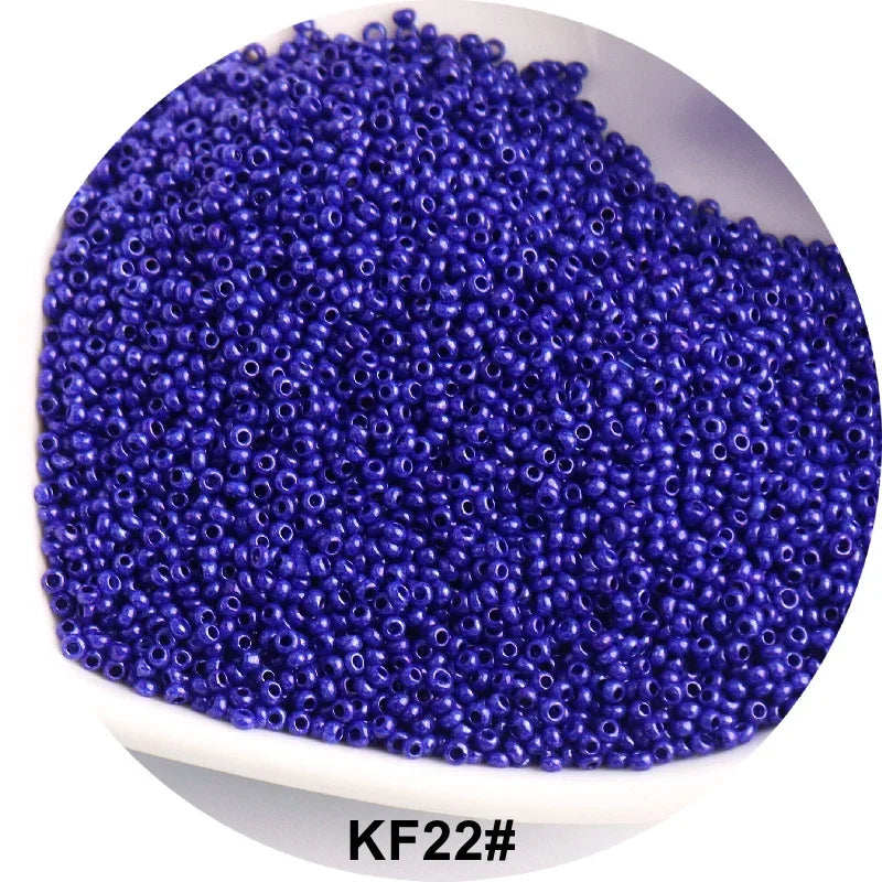 A pile of purple glass seed beads is shown in a white dish.