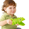 A toddler holds a green plastic dinosaur toy, demonstrating its size and grip for play.