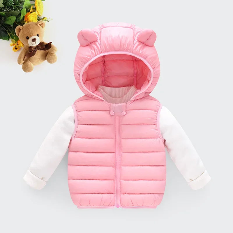A pink hooded cotton vest for kids with long sleeves and a matching teddy bear in the background.