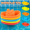 A set of colorful plastic bath toys including a boat and beach toy floating in blue water.