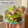 A miniature forest cabin building block set featuring a house, greenhouse, and windmill built on a blue base.