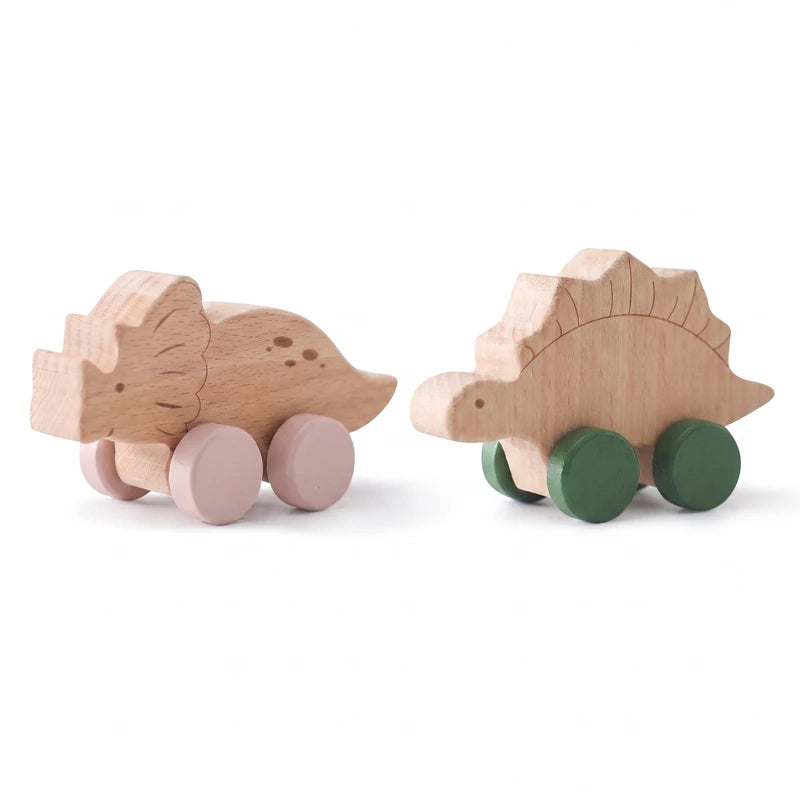 A wooden dinosaur teether toy car with light wood body and green wheels.