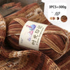 A close-up of three skeins of brown gradient acrylic yarn used for knitting or crochet.