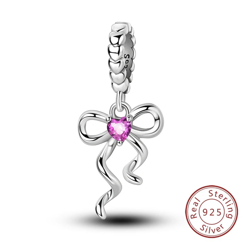 A sterling silver heart charm bead with a delicate chain and a bow design.