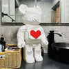 A white bear building block display model with a red heart cutout, placed on a dark countertop.