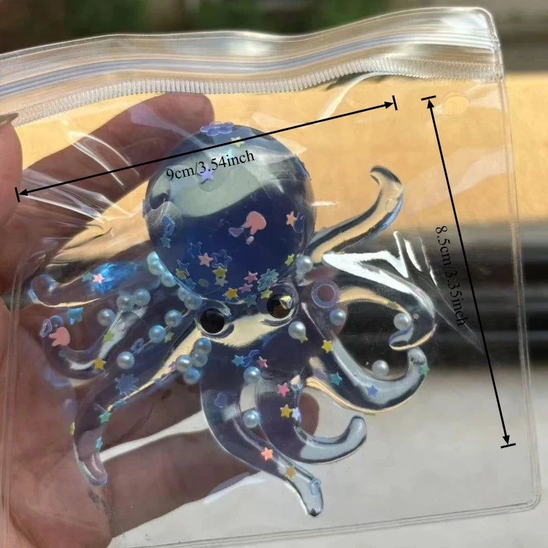 A clear plastic pouch contains a blue stretchable octopus stress ball with tentacles and stars.