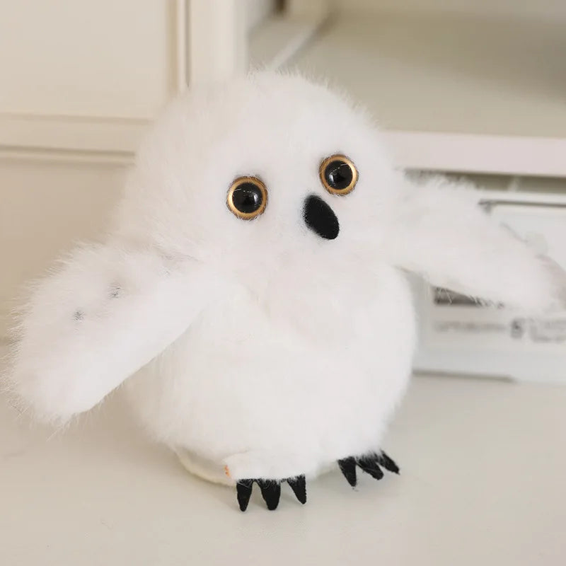 A fluffy white cartoon bird plush with black accents, used as a keychain or pendant.