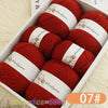 A box of red wool yarn skeins for knitting, showing various colors and textures.