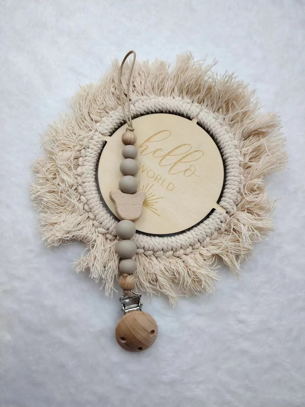 A personalized wooden baby pacifier clip featuring silicone beads and a natural fiber wreath.