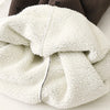 A close-up of a white fleece garment with a subtle polka dot texture, folded and draped.