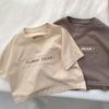 A light beige short-sleeve t-shirt with the text GUMMY BEAR printed on the chest, shown flat lay.
