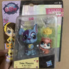 A set of three Littlest Pet Shop animal figures, including a blue cat, a pink rabbit, and a yellow flower, packaged in clear 