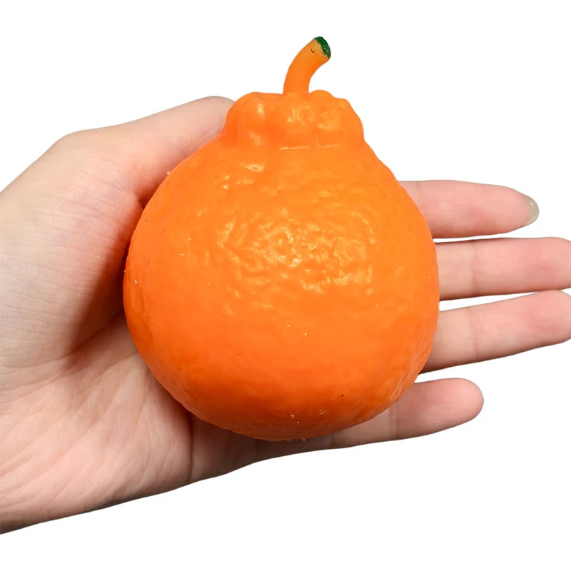An orange tangerine-shaped squishy stress relief toy is held in a person's hand.