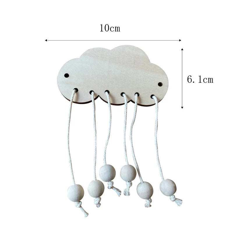 A light wood cloud shaped DIY Montessori busy board with hanging sensory balls for toddlers.