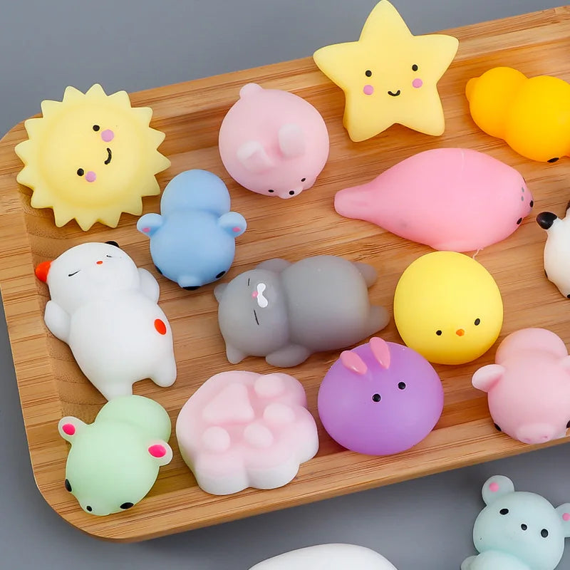 A wooden tray holds a variety of colorful mochi squishy toys shaped like various cute animals and stars.