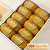 A box filled with ten balls of yellow merino wool yarn labeled Merino Wool Yarn