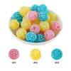 A bowl filled with various colors of iridescent rhinestone resin beads for jewelry making
