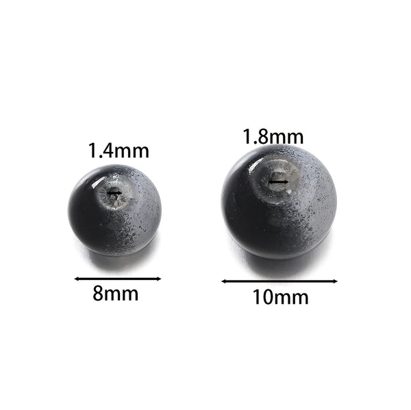 Zwei dunkle Glaskratzperlen, Maße 1,4 mm und 1,8 mm.