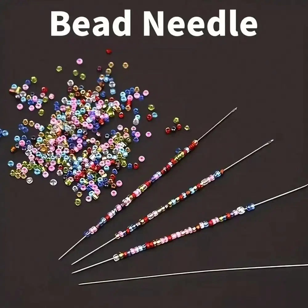 A collection of ultra-fine metal bead needles with colorful beads scattered and laid out on a dark surface.