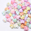 A pile of colorful, iridescent heart-shaped acrylic beads for jewelry making.