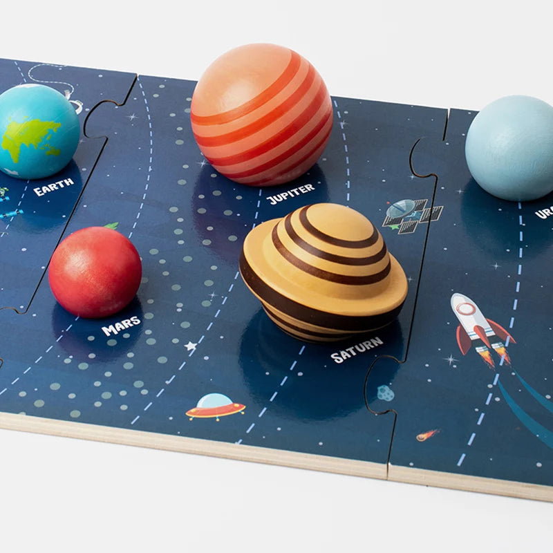 A wooden solar system puzzle featuring planets like Earth, Jupiter, Mars, and Saturn on a dark blue background.