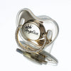 A clear silicone baby pacifier featuring a crown design and a custom name engraved on the body.
