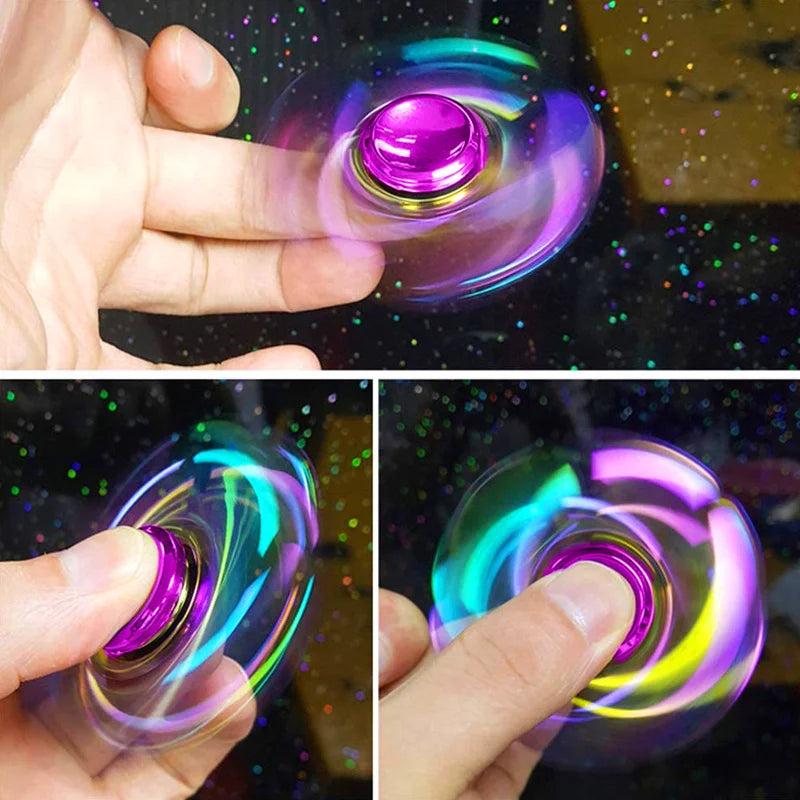 A hand spins a colorful metal fidget spinner, showing vibrant iridescent light and motion.