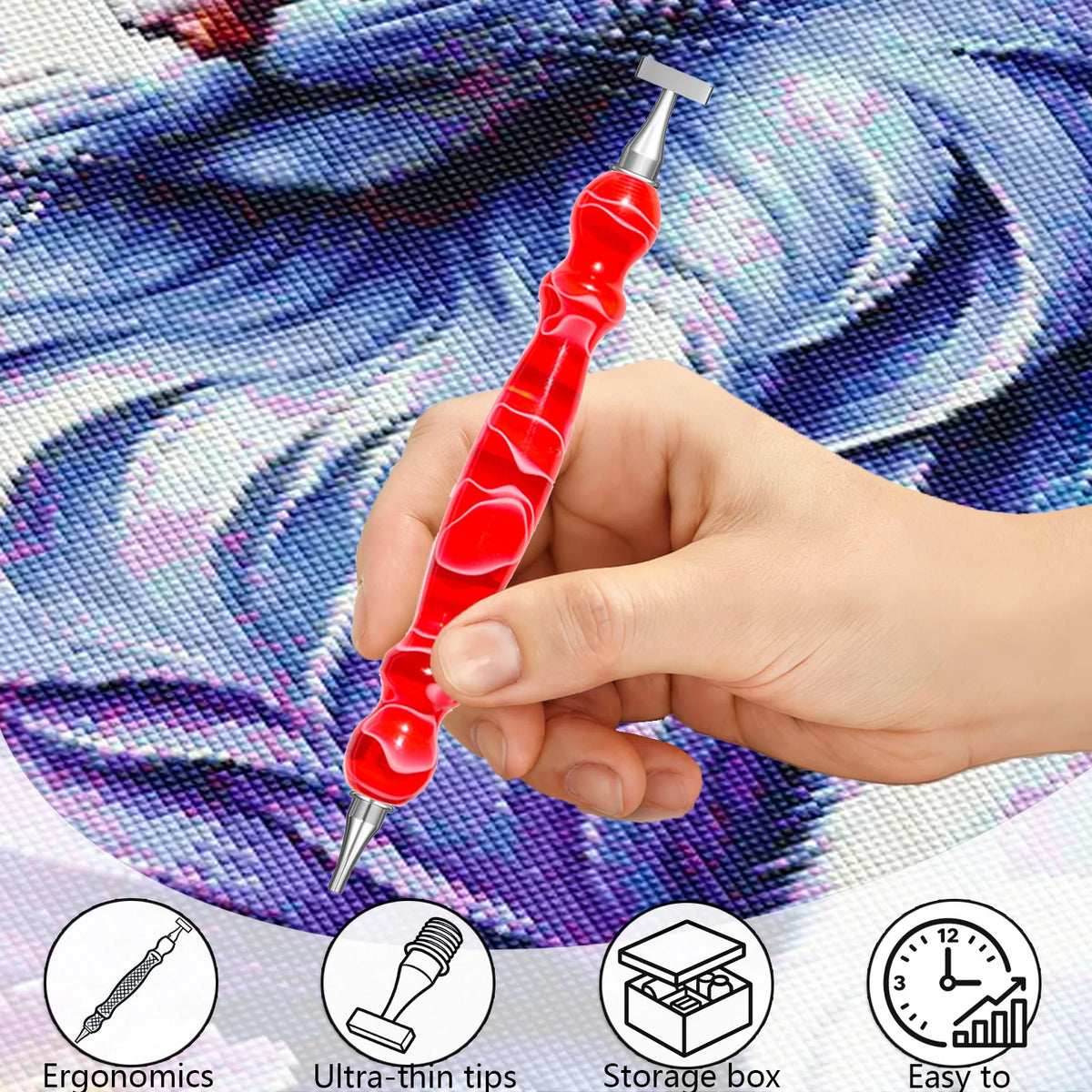 A hand holds a red resin diamond art pen with an interchangeable stainless steel tip against a purple patterned background.