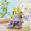 A purple woodland cabin mini building set featuring yellow and purple flowers and greenery.