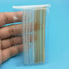 A hand holds a clear plastic package containing multiple transparent ring size adjusters.