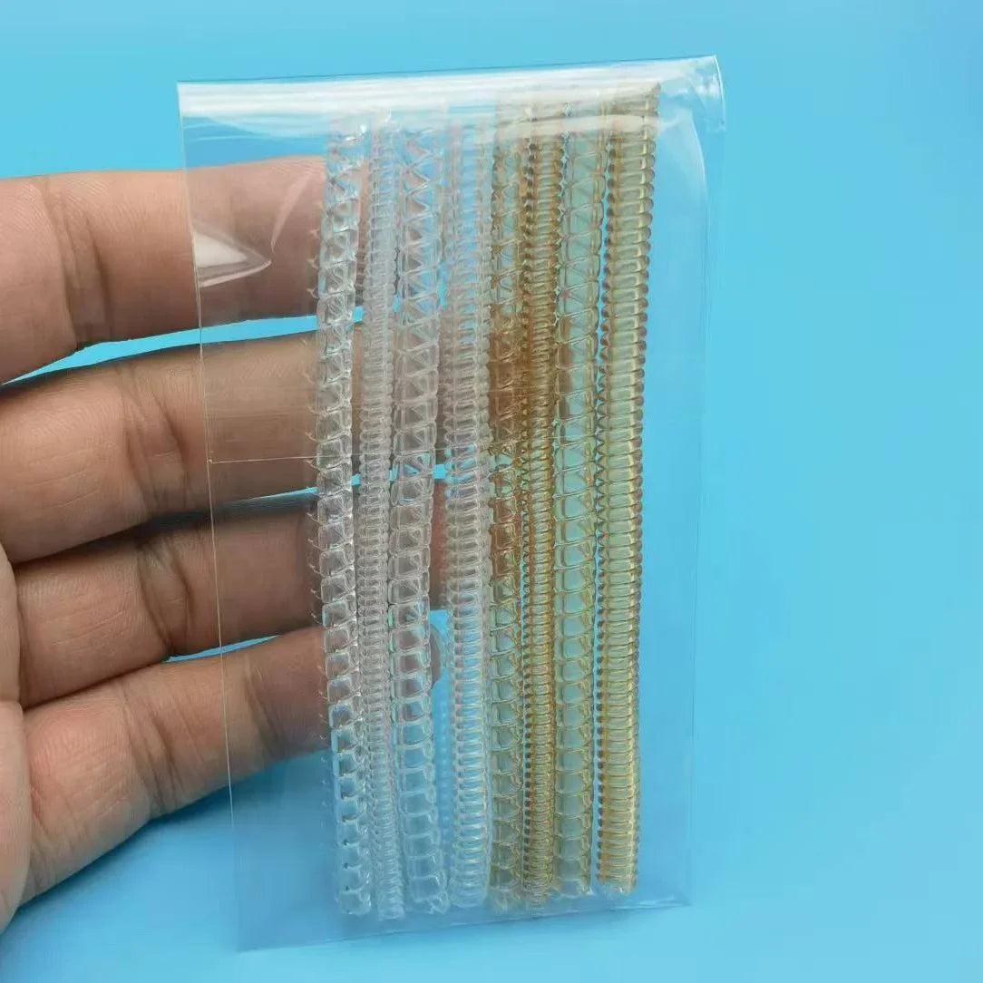 A hand holds a clear plastic package containing multiple transparent ring size adjusters.