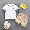 A set of a white short sleeve t-shirt and beige shorts for a boy
