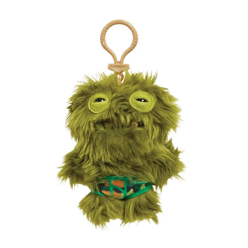 A fuzzy green plush monster with large eyes and an orange loop keychain.