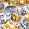 A close-up of various gold and silver stainless steel earring stud bases and backs for DIY jewelry making.