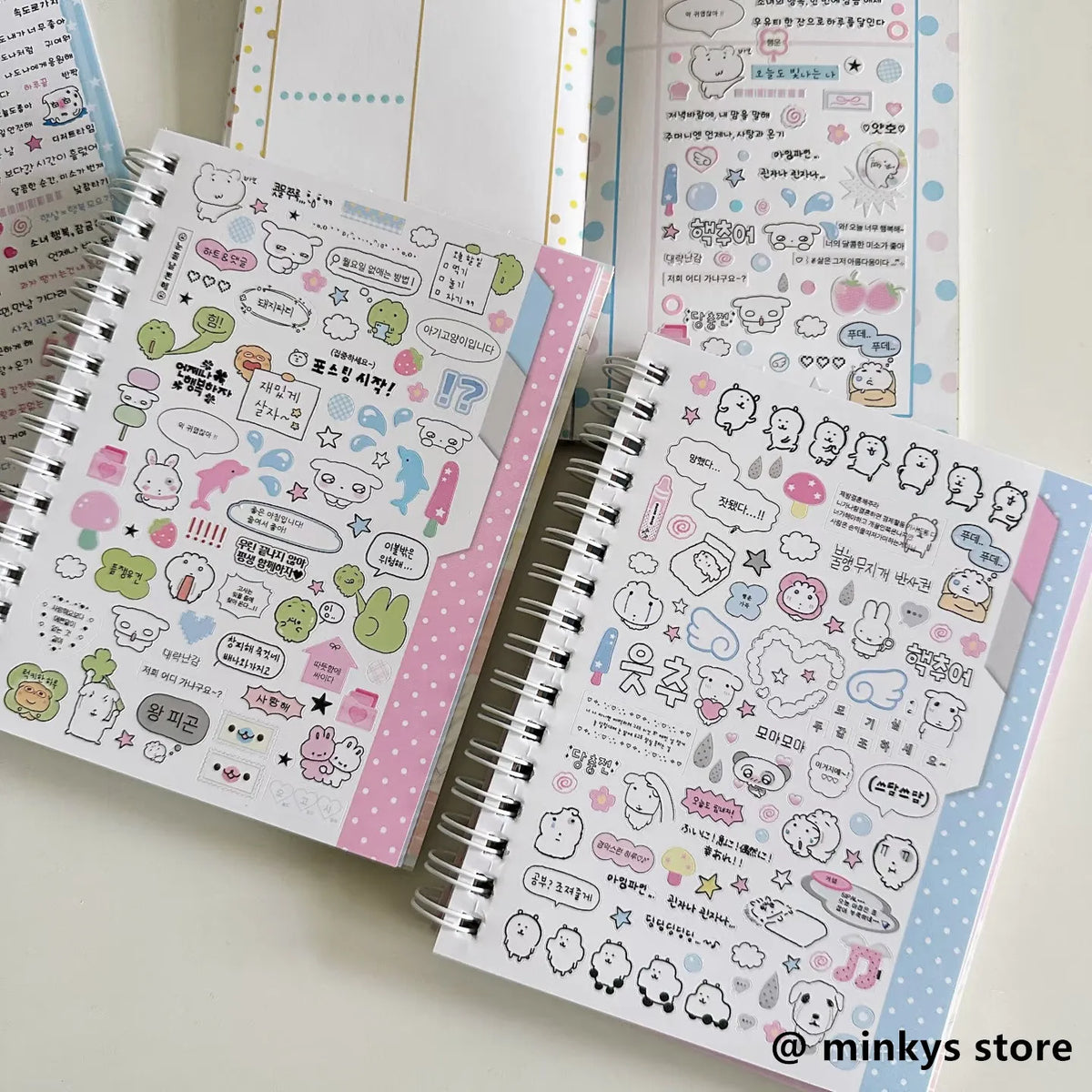 A collection of pink and white kawaii stickers in a spiral notebook for journaling and scrapbooking