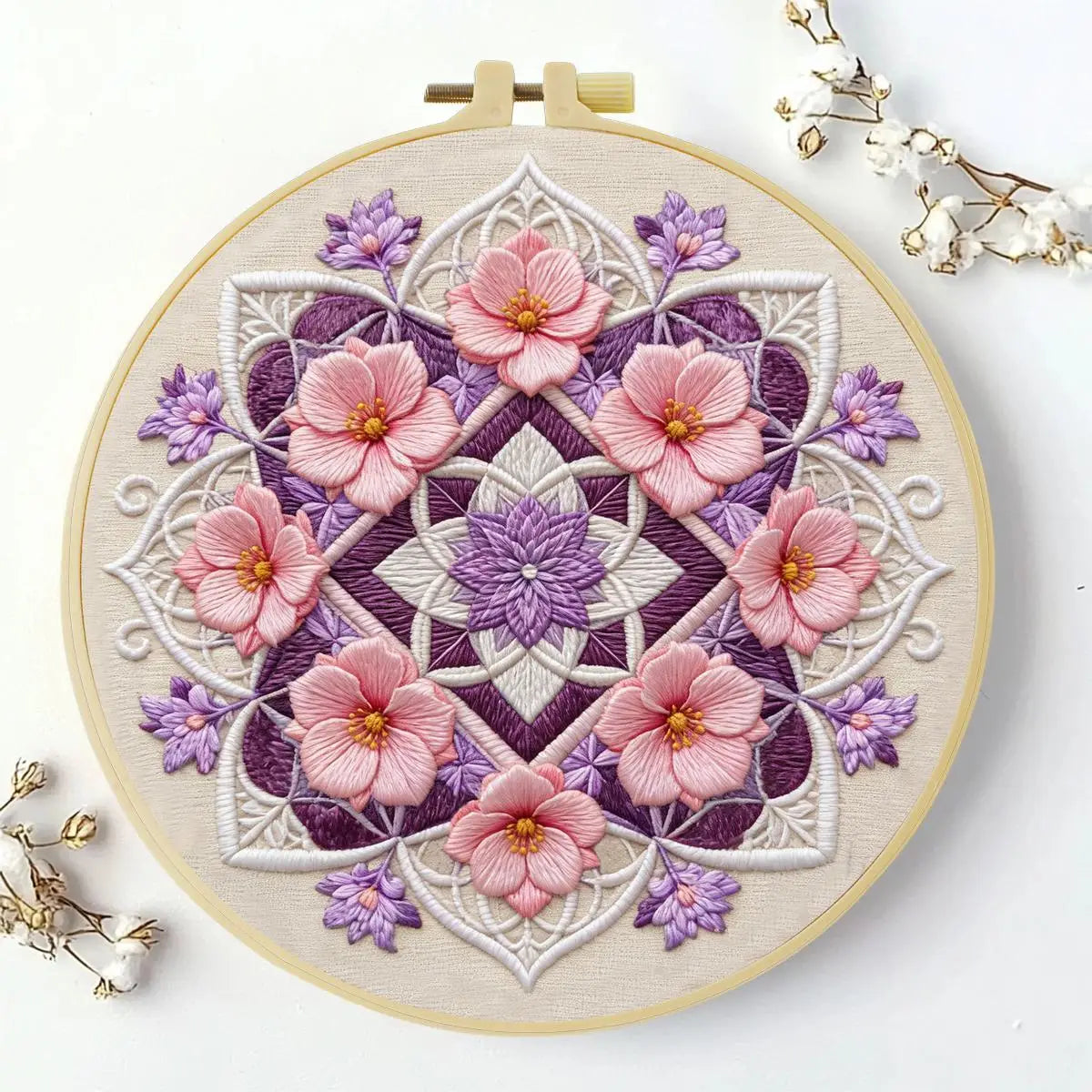 A round embroidery design featuring pink and purple flowers on a beige fabric background.