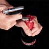 A hand holds a silver guitar capo and a red velvet guitar cap.