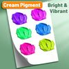 A sheet of cream pigment showing five vibrant colors: purple, magenta, blue, cyan, and lime green.