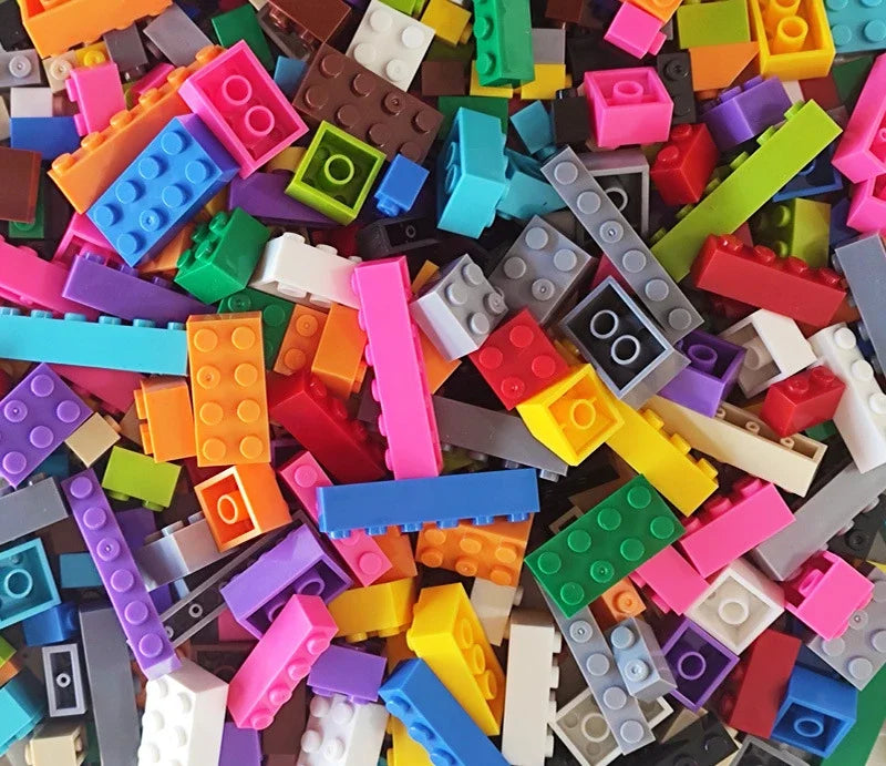 A close-up view of a large assortment of colorful plastic building blocks in various shapes and colors.