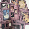A collection of purple and gold oracle cards featuring themes like Hope, Serenity, and various goddess imagery.
