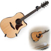 A light wood acoustic guitar is shown with a black strap and a wall mount hanger.